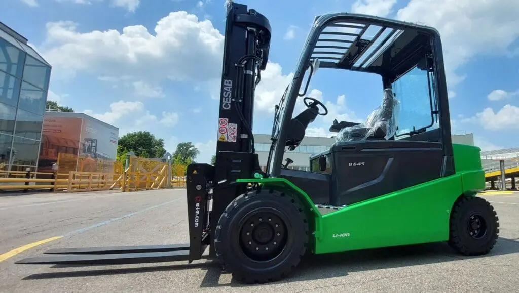 Green CESAB B645 Li-ion forklift outside in a company yard, side view. - Prince Maasdijk