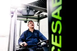 Driver in the cab of a CESAB forklift, looking up while operating the machine. - Prince Maasdijk