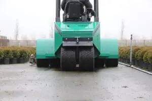 Rear view of the Prins Tiger XXL-E forklift driving between rows of potted plants at a nursery. - Prince Maasdijk