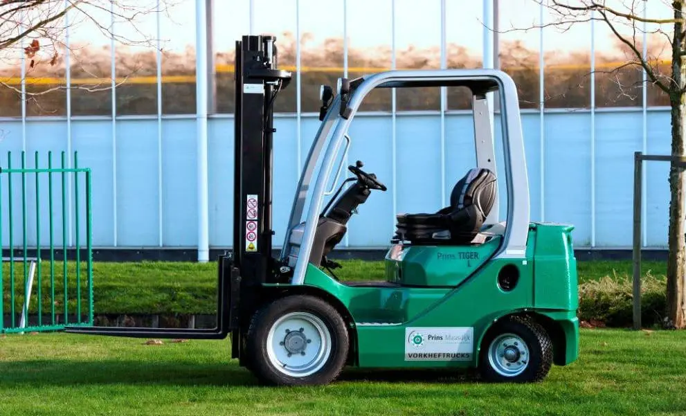 Green Prins Tiger L forklift from Prins Maasdijk Forklifts, side view outside on a lawn. - Prince Maasdijk