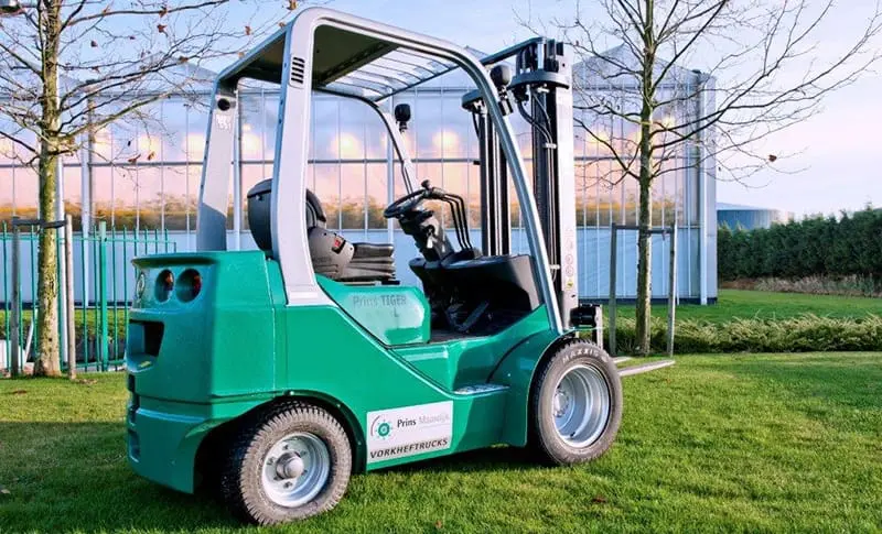 Green Prins Tiger L forklift from Prins Maasdijk Forklifts, rear-side view outside on a lawn. - Prince Maasdijk