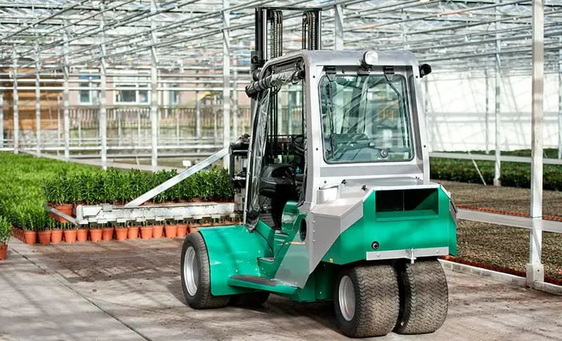 Green Prince Tiger XXL closed-cab forklift in a greenhouse, front view with plants in the background. - Prince Maasdijk